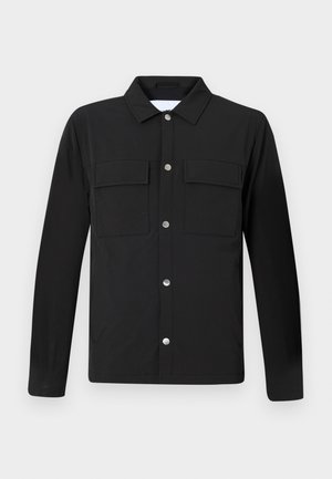 Black jacket with a collar, two chest pockets, and silver snap buttons. Made of smooth fabric with a straight cut and long sleeves.