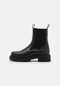 Sorte skinn ankle boots med elastiske sidepaneler og løkkede trekkb�ånd, med en kraftig svart såle og glatt finish.