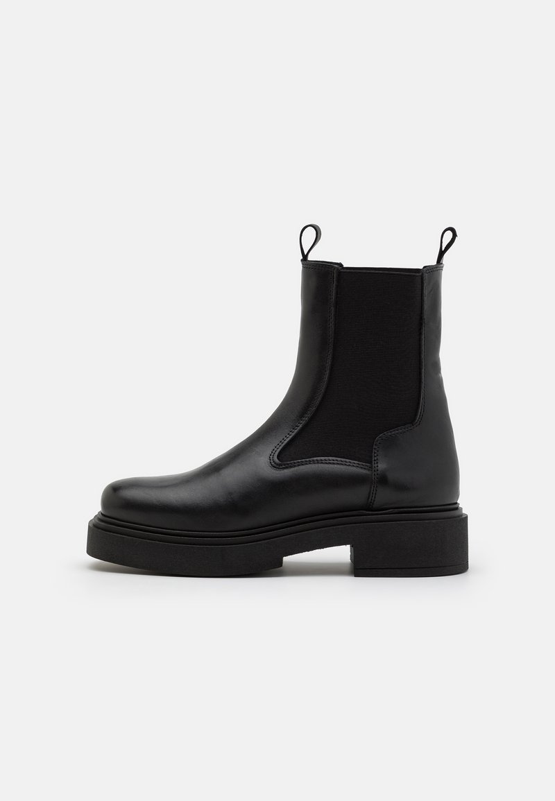 Sorte skinn ankle boots med elastiske sidepaneler og løkkede trekkbånd, med en kraftig svart såle og glatt finish.