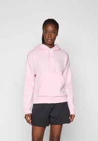 Sweat à capuche rose clair avec une poche avant, un cordon de serrage et un logo blanc. Associé à un short gris foncé. Tissu en coton, coupe décontractée.