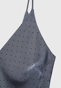 Szara satynowa sukienka na ramiączkach, ozdobiona małymi czarnymi groszkami równomiernie rozmieszczonymi na materiale.