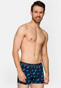 Bokserki w kolorze granatowym z wzorem turkusowych kontrolerów do gier, z czarnym elastycznym pasem z nadrukowaną nazwą marki.