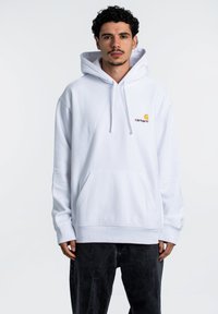 Sudadera blanca con capucha, hecha de algod�ón, con un bolsillo frontal y puños acanalados. Logo en naranja y amarillo en la parte izquierda del pecho.
