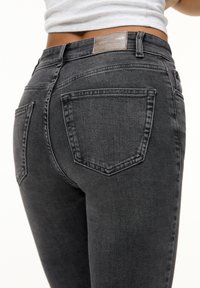 Mustat denim-farkut, joissa on kapea istuvuus, korkea vyötärö, kaksi takataskua ja nahkainen logo-merkki takana.