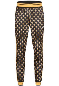 Pantalon de jogging noir avec motif répété de fleurs de lys dorées, taille et poignets dorés, et deux bandes latérales dorées.