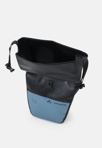 Borsa impermeabile nera con un pannello inferiore blu, finitura testurizzata, chiusura a rotolo e spallacci regolabili. Presenta un logo e un testo sul riciclo.