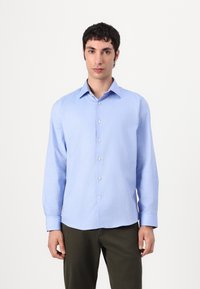 Gai zils garām piedurknēm krekls, kas izgatavots no gludas auduma, ar pogājamu priekšpusi, klasisku apkakli un noapaļotu malu.