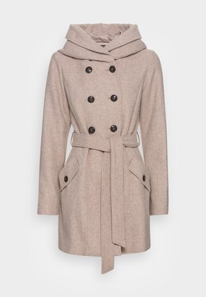 Manteau beige clair croisé avec six boutons noirs, large ceinture, capuche et deux poches avant à rabats.