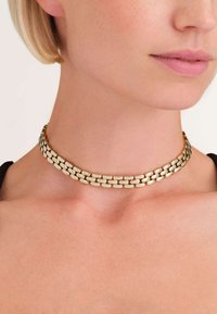 Naszyjnik choker w kolorze złotym z podwójnym wzorem ogniw, z gładkimi, owalnymi ogniwami, które tworzą płynny wygląd i strukturę.