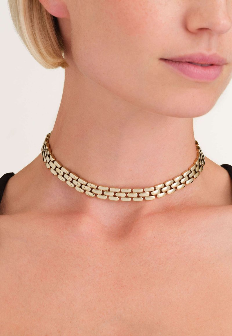 Naszyjnik choker w kolorze złotym z podwójnym wzorem ogniw, z gładkimi, owalnymi ogniwami, które tworzą płynny wygląd i strukturę.