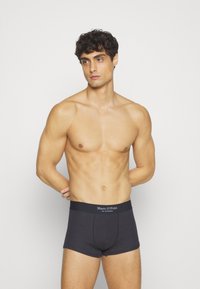 Tummanharmaat boxerit, jotka on valmistettu pehmeästä kankaasta. Ominaisuuksiin kuuluu joustava vyötärö, jossa on "Marc O'Polo" -brändäys. Istuva muotoilu korostaa vartalon muotoa.