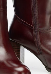 Bordowe skórzane botki za kostkę z bocznym zamkiem, charakteryzujące się gładkim wykończeniem i drewnianym, prostokątnym obcasem, podkreślające czyste linie i kunszt wykonania.