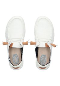 Baskets blanches en toile avec une finition texturée, comportant des accents en cuir marron et des lacets blancs. La conception intérieure comprend une doublure à motifs.