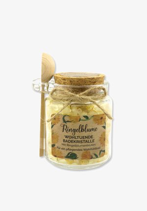Glasgefäß gefüllt mit gelben Bade-Kristallen, verschlossen mit einem Korkdeckel. Ein Holzlöffel ist mit einer Schnur befestigt. Das Etikett zeigt ein florales Design und Text.