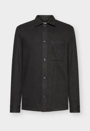 Chaqueta de camisa negra de manga larga hecha de un tejido texturizado, con un collar puntiagudo, botones frontales y un solo bolsillo en el pecho.