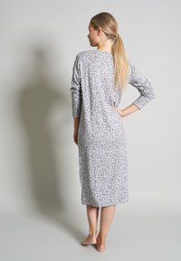 Grå leopardmönstrad nattklänning med långa ärmar, knälång design, mjukt tyg, har en avslappnad passform och sidofickor i fållen.