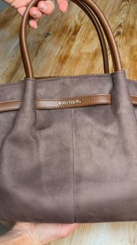 Brown suede handbag with two brown leather handles. Features a subtle texture and a logo plate with "Valentino" in gold.