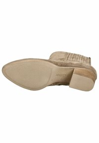 Stivale alla caviglia beige in suede con suola in gomma texturizzata e tacco basso impilato. Dettaglio di cucitura verticale sul gambale.