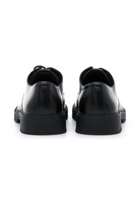 Schwarze Lederschuhe mit abgerundetem Zeh, glatter Oberfläche und Gummisohle. Verfügen über dezente Logodetails an der Ferse und ein Schnürdesign.