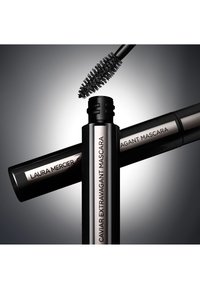 Schwarzer Mascara-Tube mit silbernen Akzenten, beschriftet mit "Laura Mercier Caviar Extravagant Mascara", begleitet von einem schwarzen Borstenpinsel darüber.