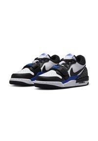 Nike sportcipő fehér, fekete és kék színsémával. Bőr alapanyag, perforált orr, párnázott domború nyak, és látható Air egység a talpban.
