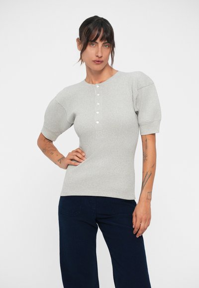 Heled hall ribatud pullover, lühikeste puffvarrukatega ja ümmarguse kaelusega, esiosal nelja nupuga palak.