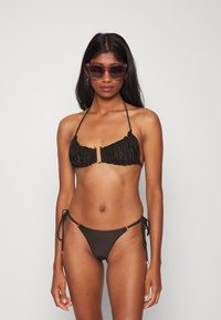 Conjunto de biquíni preto com um design franzido e detalhe em anel dourado na parte de cima, e cordões ajustáveis na parte de baixo para um estilo ajustado.