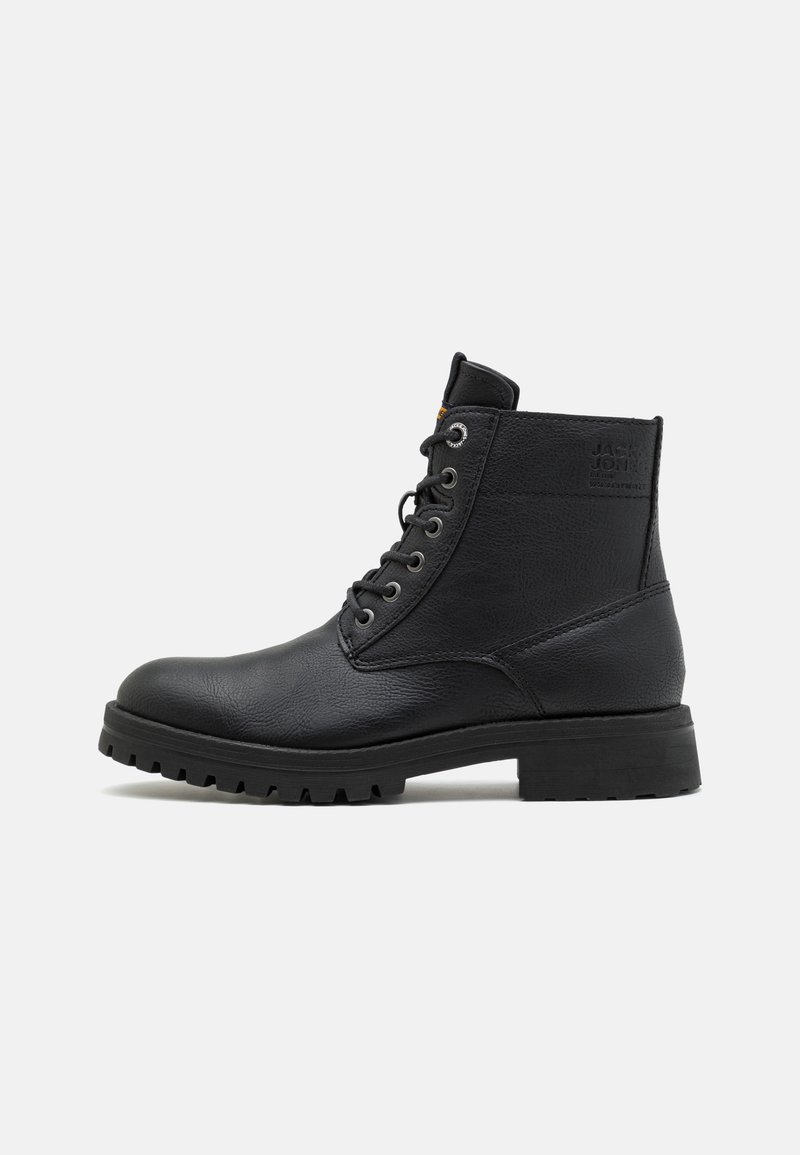 Stivaletto in pelle nera con punta tonda, occhielli in metallo e finitura texture. Suola in gomma spessa con tacche per aderenza. Logo impresso sul lato.