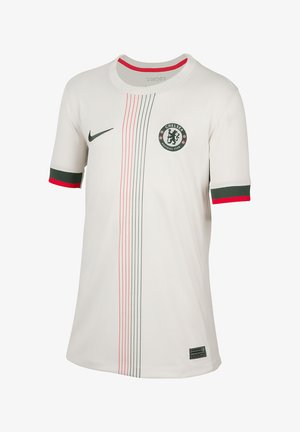 La camiseta del Chelsea Football Club, blanca con acentos en verde y rojo, presenta un cuello redondo, mangas cortas y rayas verticales. Incluye el logo del club.