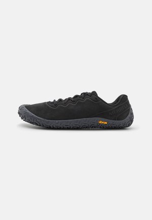 Svarta vandringsskor med en texturerad svart gummisula, som har en lågprofilsdesign, övre del i nät och en kontrasterande orange Vibram-logga.