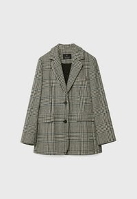 Mustavalkoinen houndstooth-kuvioinen bleiseri, jossa on halkiokäännekaulus, kaksi nappia ja kaksi etutaskua läpällä, yksinkertaisella vaalealla taustalla.