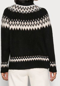 Schwarzer gestrickter Pullover mit einem weißen und beigen geometrischen Muster rund um den Halsausschnitt; lockere Passform mit gerippten Bündchen und Saum; weicher, strukturierter Stoff.