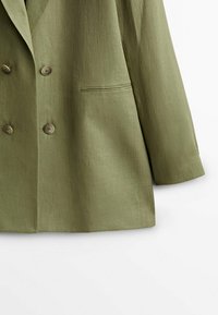 Olive green double-breasted blazer with a smooth texture, two buttons, and a single chest pocket; features tailored fit and sharp lapels.