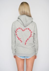 Felpa grigia chiaro con cappuccio regolabile e una grafica testuale curva di colore rosso che forma una forma a cuore sul retro. Tessuto morbido e vestibilità casual.