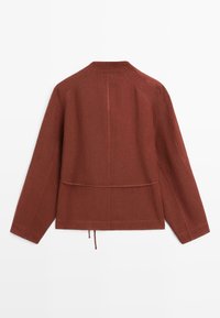 Roestkleurig jack met lange mouwen, een rechte zoom, een naaddetail over de achterkant en een verstelbaar trekkoord in de taille.