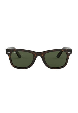 Occhiali da sole tartaruga con lenti verde scuro, caratterizzati da un design a montatura quadrata e un accento in metallo sulle tempie.