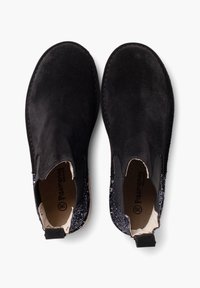 Botas de tobillo de ante negro con paneles laterales elásticos. Acentos brillantes en el tacón. Punta redondeada y detalles cosidos a lo largo del borde.