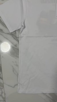 White cotton T-shirt with short sleeves, smooth texture, classic crew neck design, and no visible patterns or accents. Flat layout on marble background.