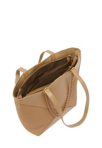 Tygväska i ljus beige, med släta och texturerade paneler, flätade handtagsdetaljer och en innerficka med dragkedja med mjukt foder.
