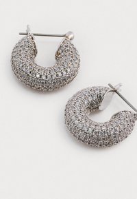 Sølvfarvede hoopearrings med en struktureret overflade, prydet med små, klare krystaller, med en post- og hængsel-lukning.