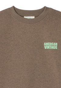 Felpa marrone in tessuto morbido, con scollo rotondo e piccolo logo "AMERICAN VINTAGE" verde menta nella parte superiore sinistra.