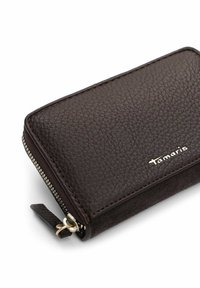 Brown leather wallet with a textured finish, accented by gold hardware and a zip closure. Features a logo on the front.