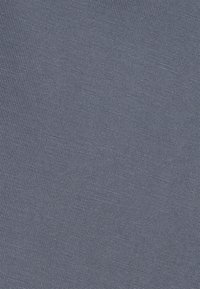 Tecido texturizado numa tonalidade azul média, apresenta um padrão de grelha com pequenos quadrados, feito de material tecido, conferindo uma aparência durável.