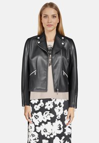 Veste de moto en cuir noir avec poches zippées et accents en métal argenté. Elle dispose d'un col à revers et d'un design ajusté.