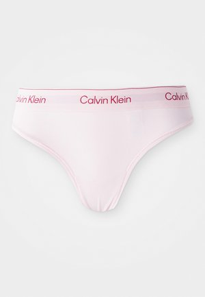 Šviesiai rožinis medvilninis thong tipo kelnaitės su švelnia tekstūra. Savybės: raudonas juostos dizainas su Calvin Klein logotipu. Klasikinis apatinio trikotažo dizainas.