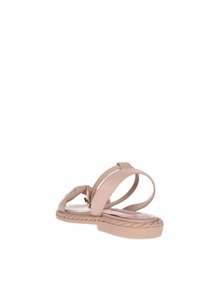 Sandali piatti color nude con suola intrecciata, cinturini eleganti e un accento decorativo. Realizzati in materiale sintetico, con una consistenza liscia.