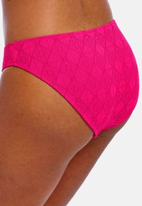 Bas de maillot de bain taille haute rose avec un motif géométrique texturé, présentant une finition lisse et une taille élastique pour plus de confort.