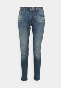 Tmavě modré džíny s úzkým střihem, s bledými místy, pěti kapsami a standardním zapínáním na knoflík a zip.