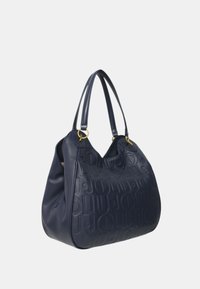 Borsa hobo in pelle blu navy con design del logo in rilievo, doppie spalline e dettagli in metallo dorato. Texture liscia, forma curvata.