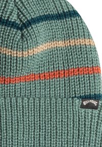Gorro de punto en azul verdoso con rayas horizontales en beige, naranja y azul. Presenta una etiqueta negra con el logo de "Billabong" en el lateral. Material texturizado.